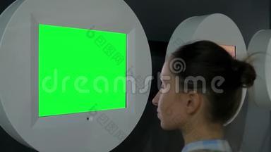 绿色屏幕概念-女人看空白绿色<strong>展示墙</strong>展览